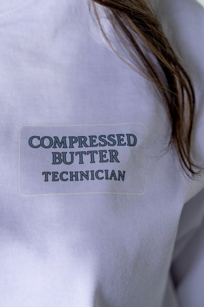 Label on a white shirt with 'Compressed Butter Technician' text