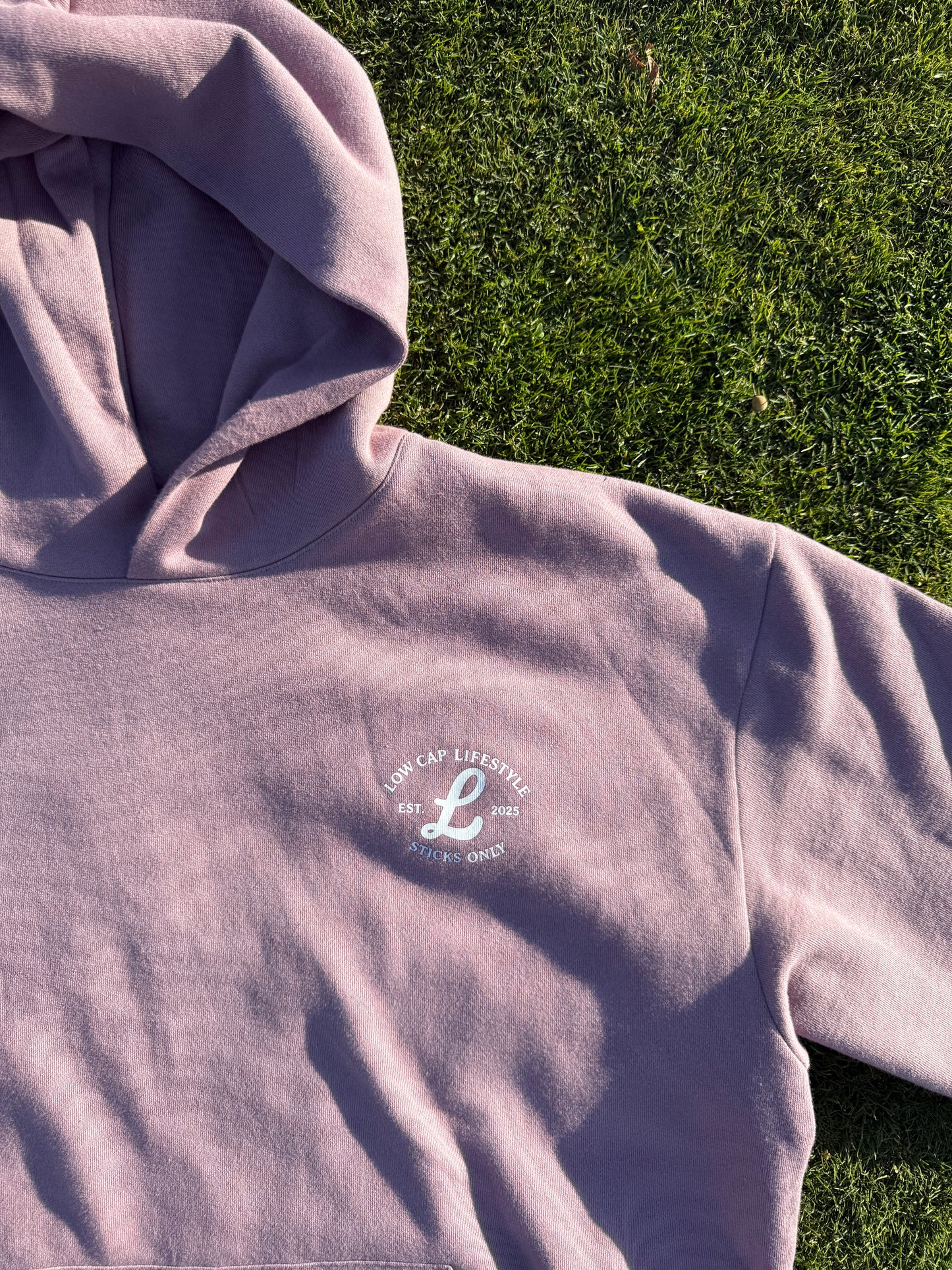 Orchid Cozy Stick hoodie Laying on the ground 