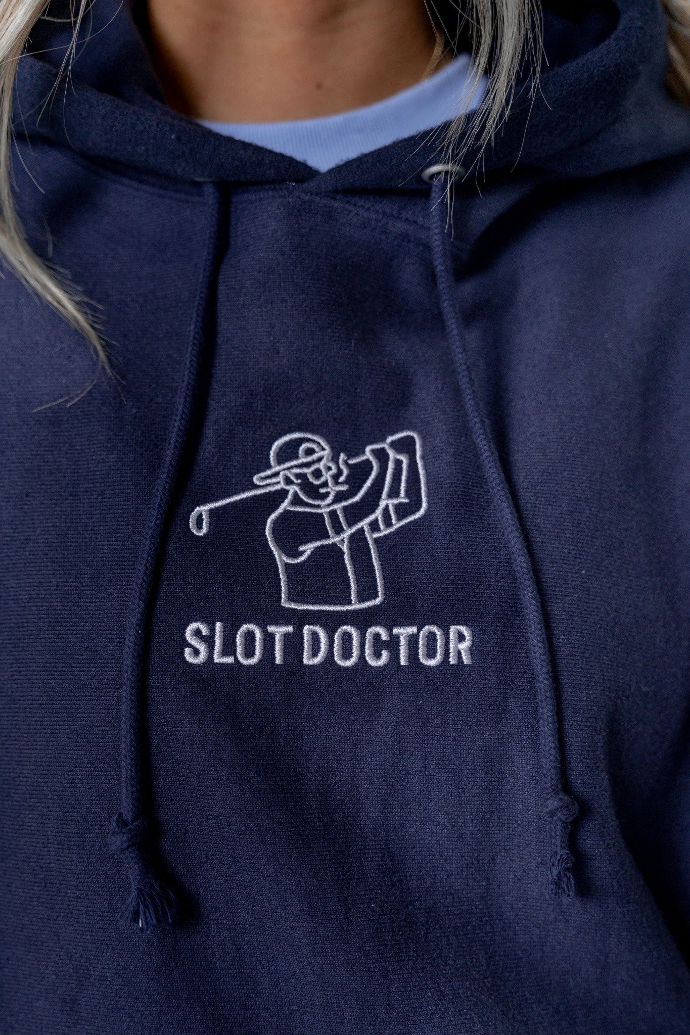 Navy blue hoodie with 'Slot Doctor' logo on a person wearing it.